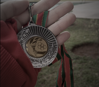 A hand holding a football medal